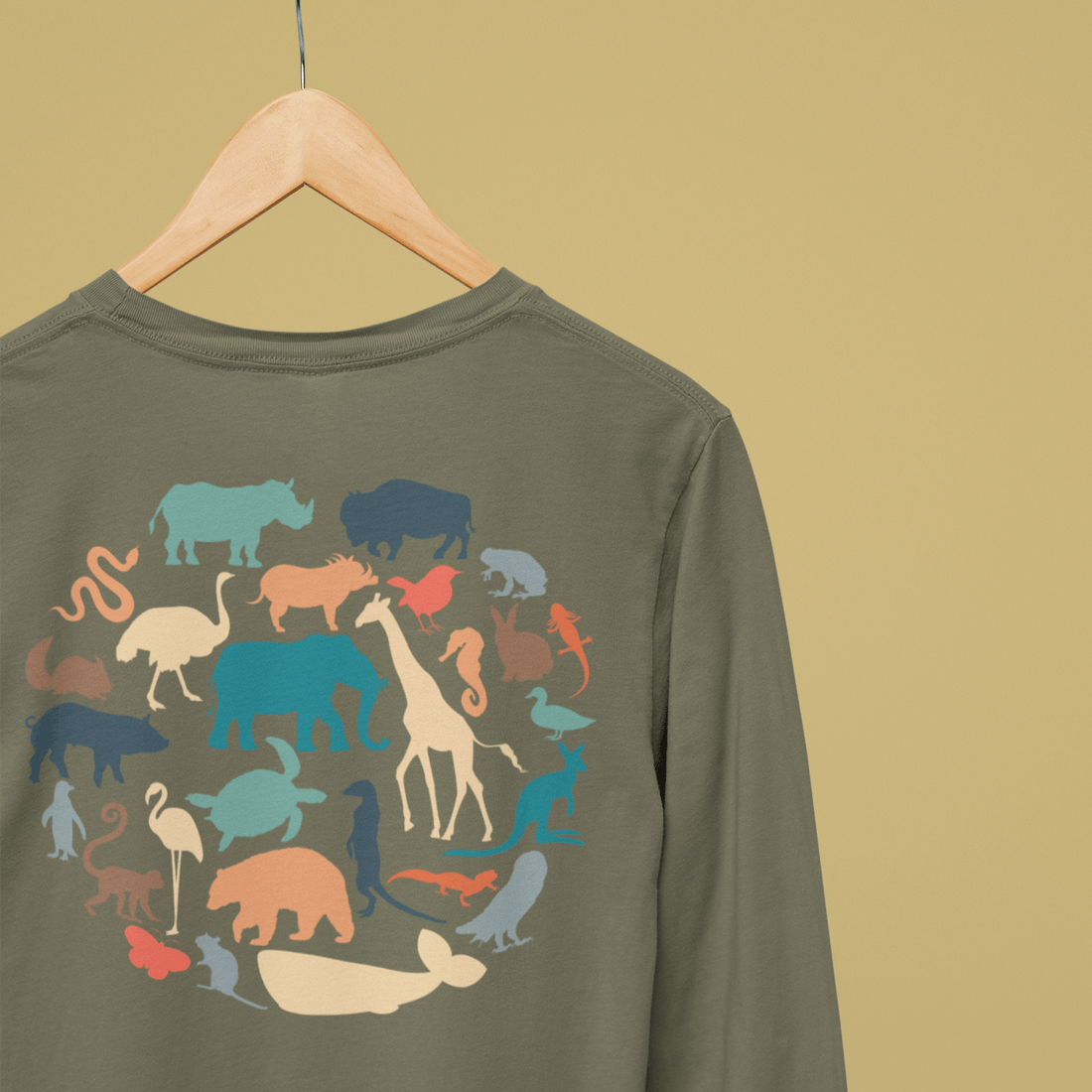 Back of green long sleeve on hanger showing grouping of animals in big circle