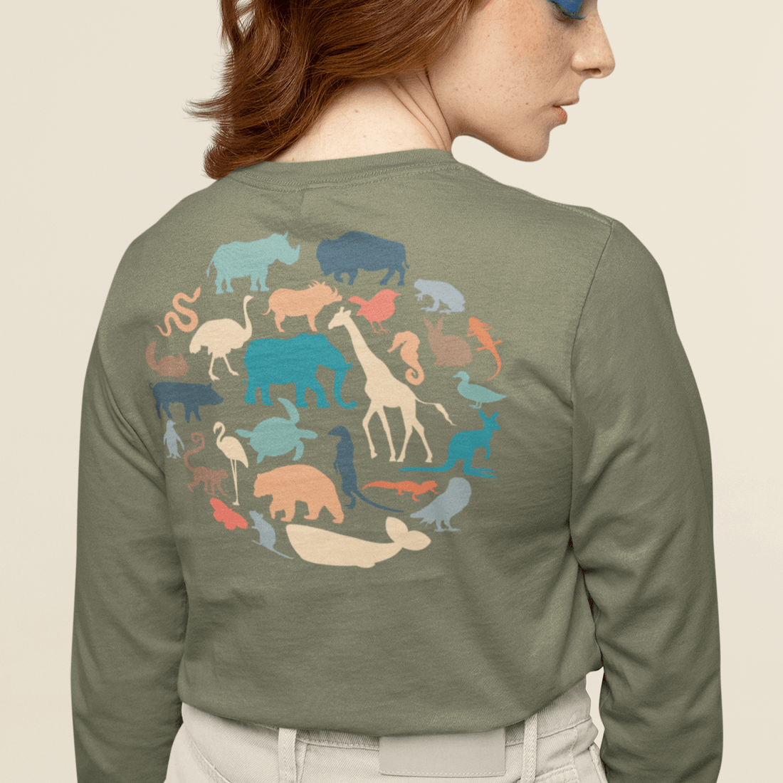 Woman wearing green long sleeve with pattern of animals in a circle on back of shirt