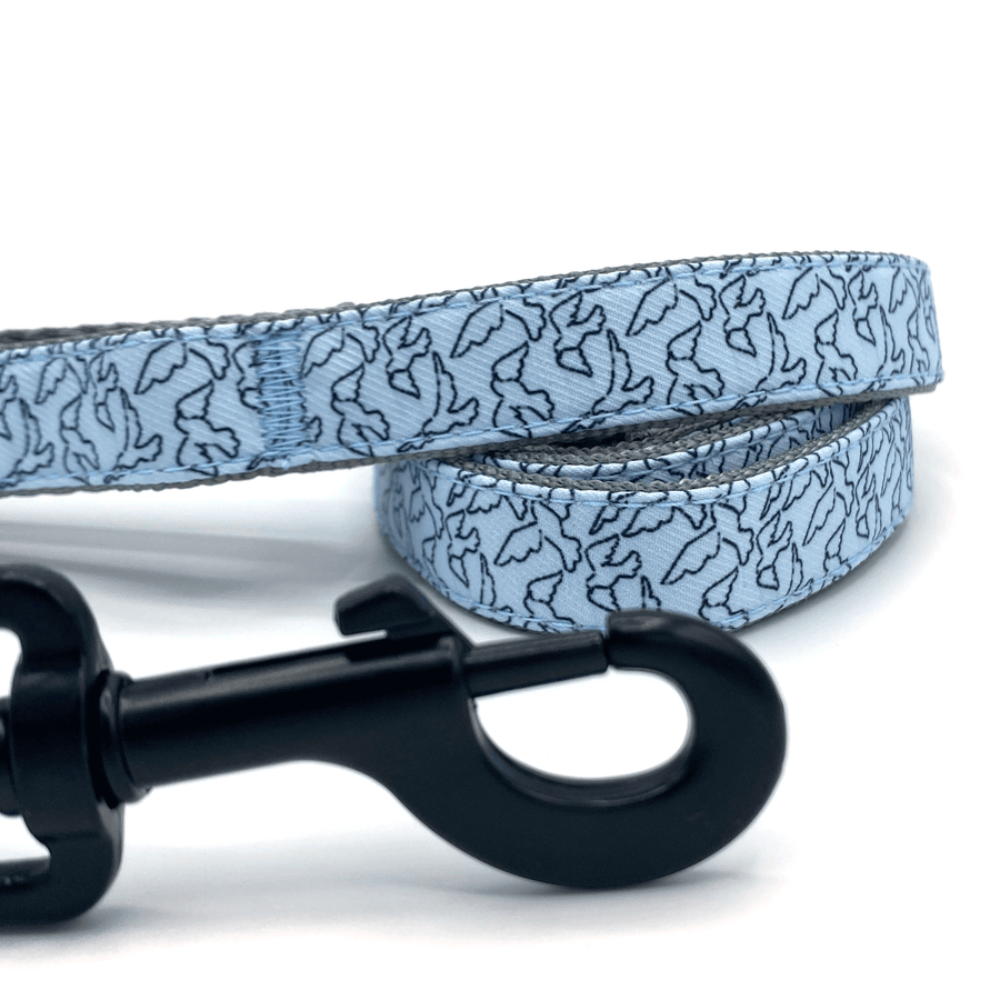 a blue leash with black outlines of birds, black hardware, and grey handles