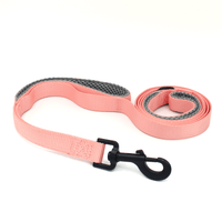 a peach colored leash with grey padded handles and black hardware