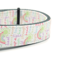 closeup of white dog collar with rainbow colored words of positivity