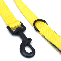 close up of dog leash clip and D ring on yellow double handle leash for secure control and durability